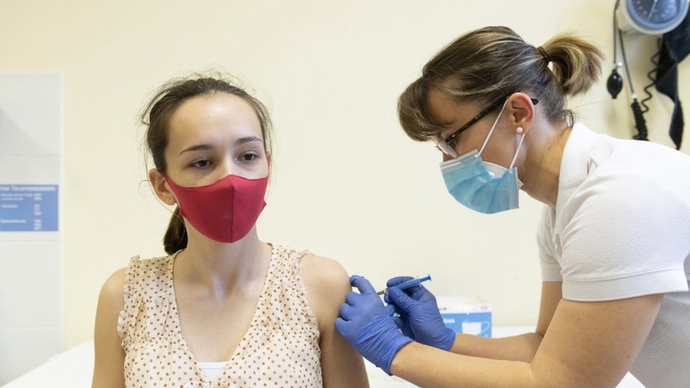 A medical worker administers the Sputnik V vaccine to a young woman in Hungary, 13 April 2021