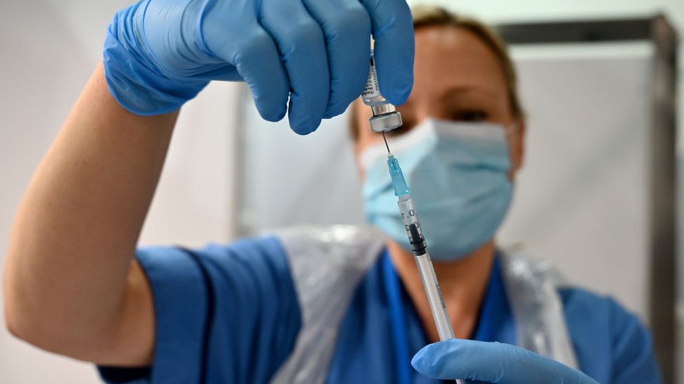 A nurse prepares a dose of the Pfizer vaccine