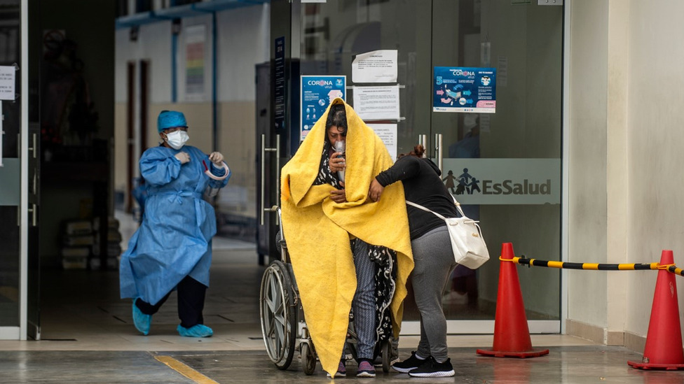 A Covid patient in a wheelchair is greeted by an doctor at the entrance to A&E in Peru