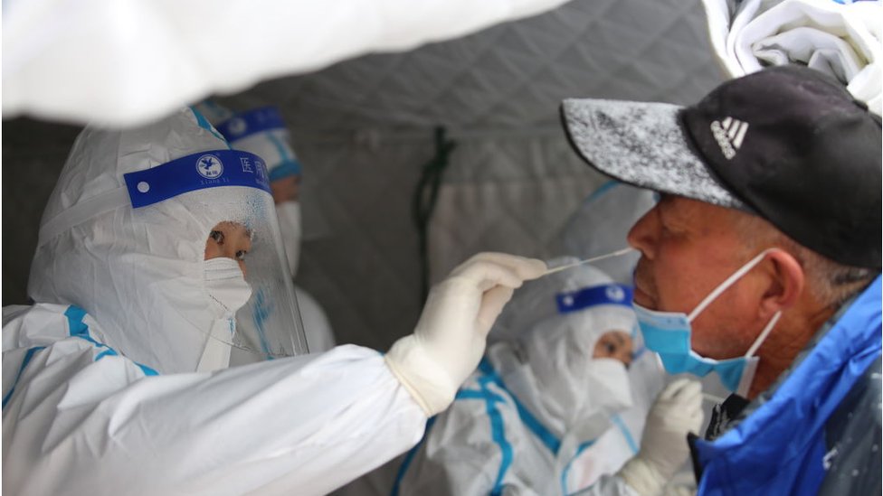 Medical workers take swab samples on residents in a mass Covid-19 test in the snow in Shandan county in northwest China's Gansu province Saturday, Nov. 06, 2021.