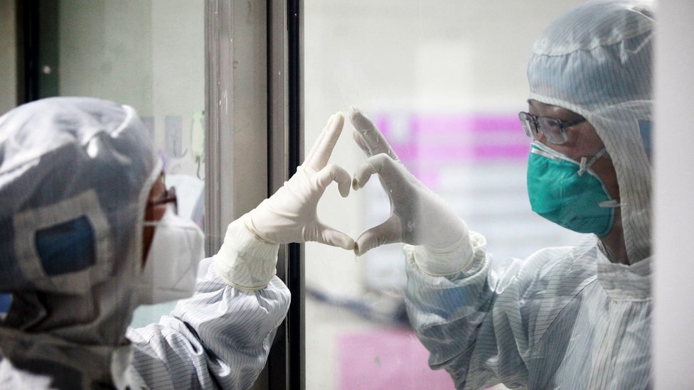 Chinese medical workers make a heart through plastic