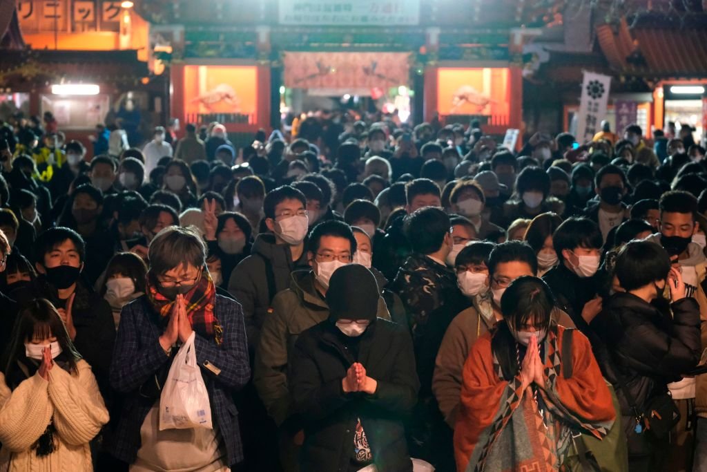 Wearing masks, people in Tokyo visit the Shinto Kanda Myojin Shrine to mark the new year