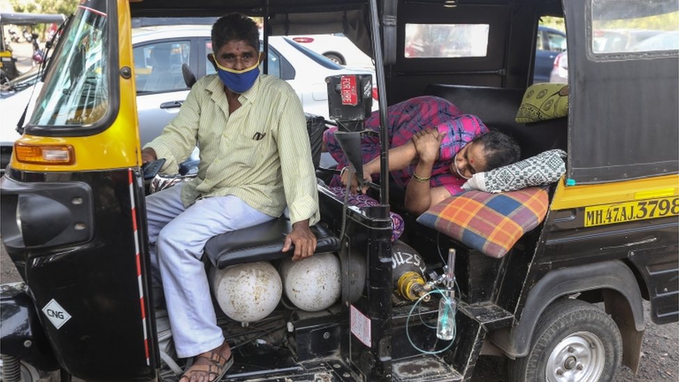 A woman lies in a rickshaw waiting for for medical assistance