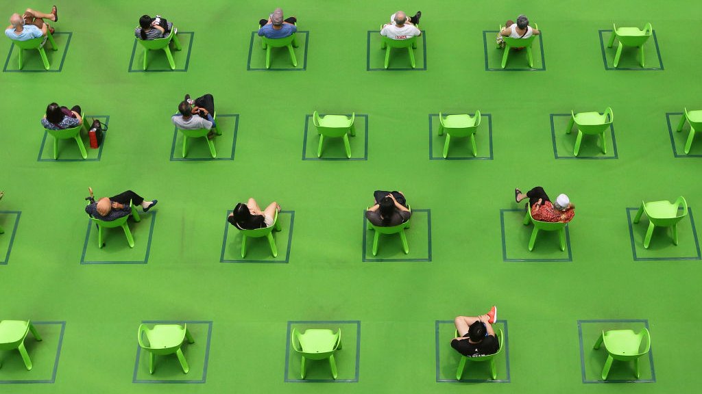 People sit on chairs marked out to maintain social distancing amid the COVID-19 pandemic on 19 March 2021 in Singapore