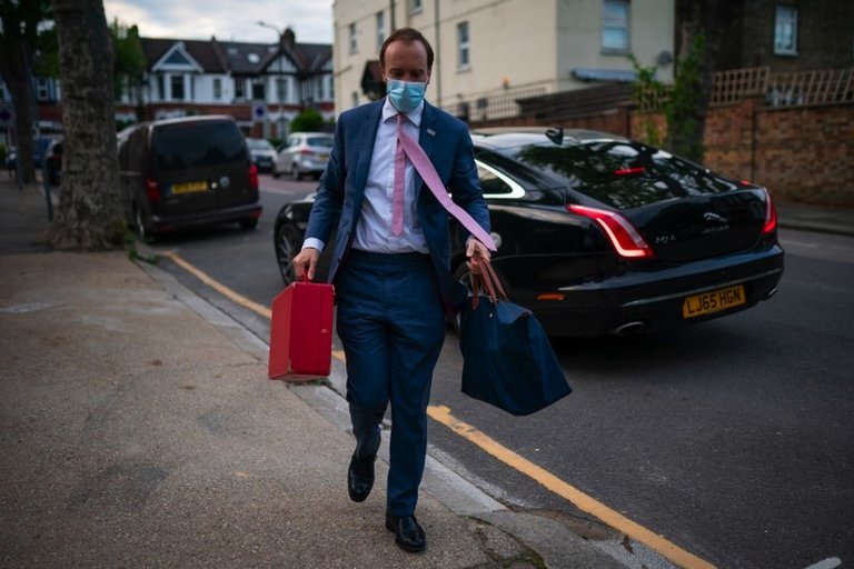 Matt Hancock carrying bags down the street