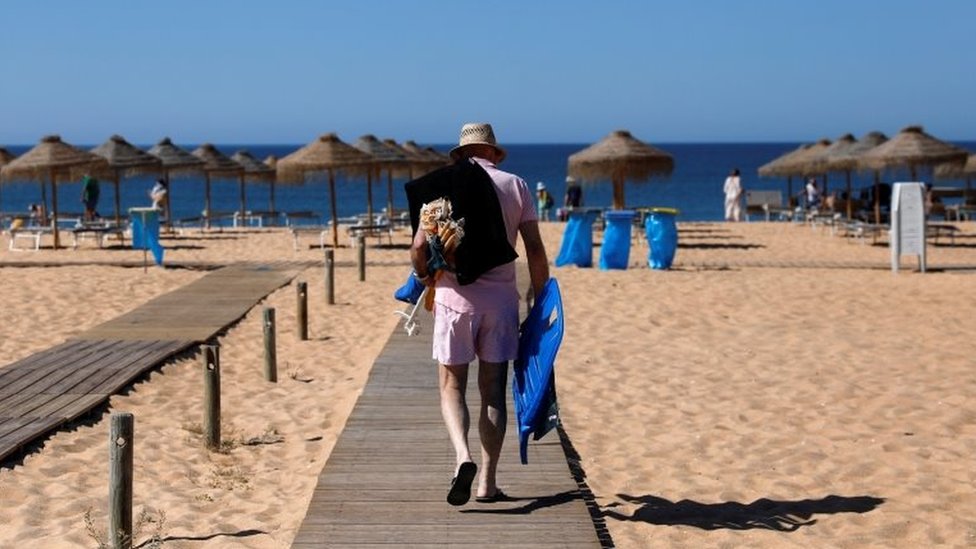 A man arrives at Vilamoura beach amid the coronavirus disease (COVID-19) pandemic, in Quarteira