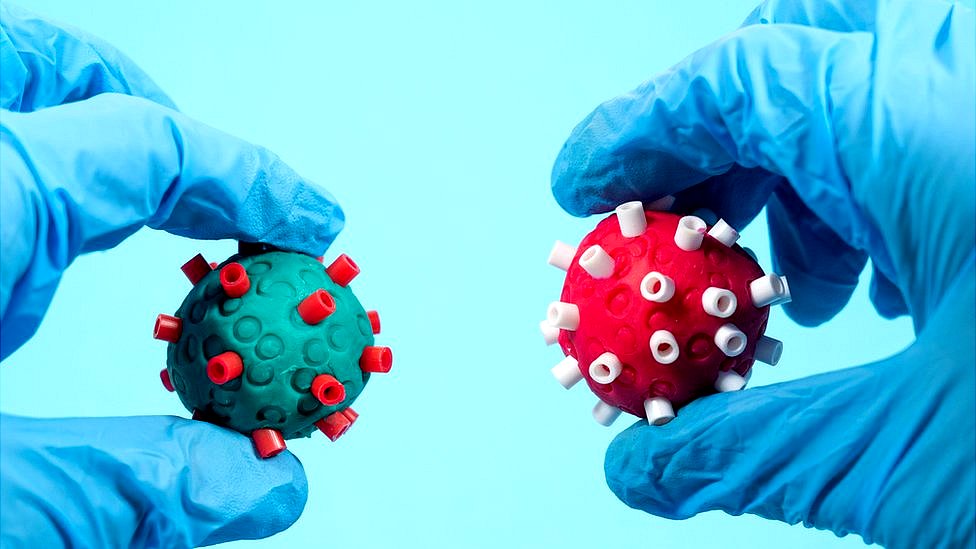 Scientist holding clay models of Covid virus